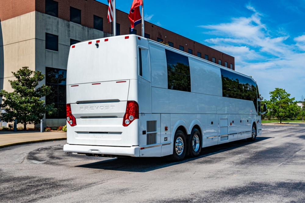 Rear side view of a Prevost H345 entertainer bus for sale, displaying its spacious exterior and modern design for long-distance travel.