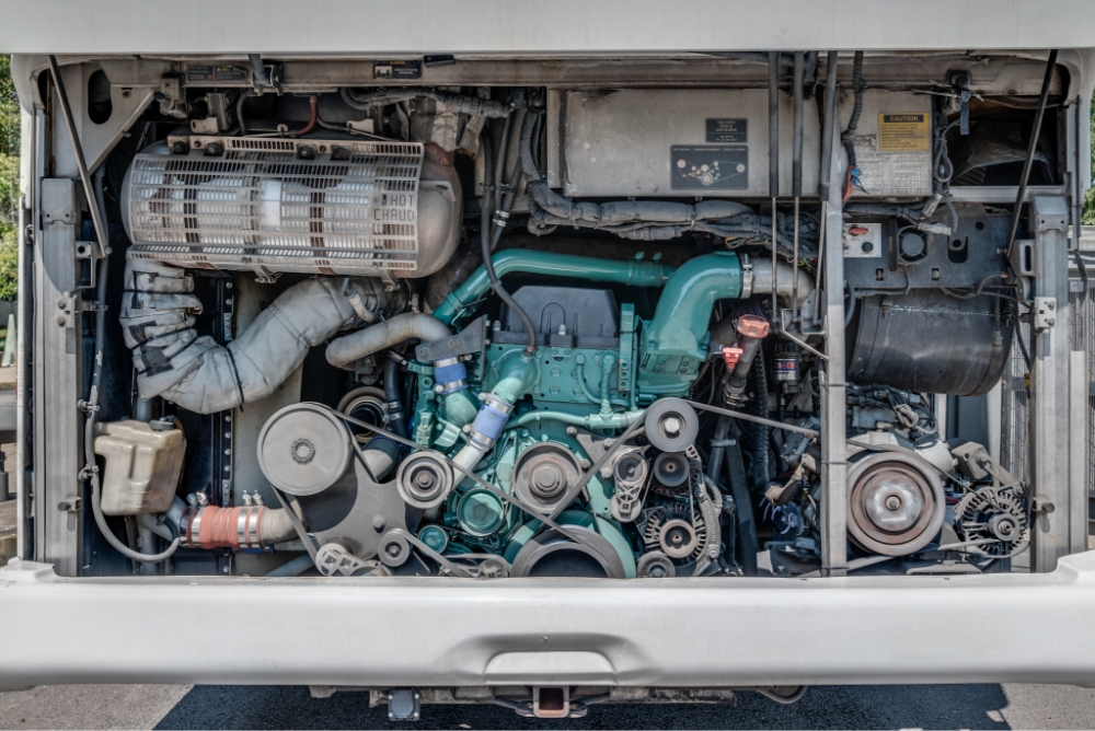 Detailed view of the engine compartment in a Prevost H345 bus conversion for sale, highlighting the powerful engine and mechanical systems for reliable entertainer bus use.