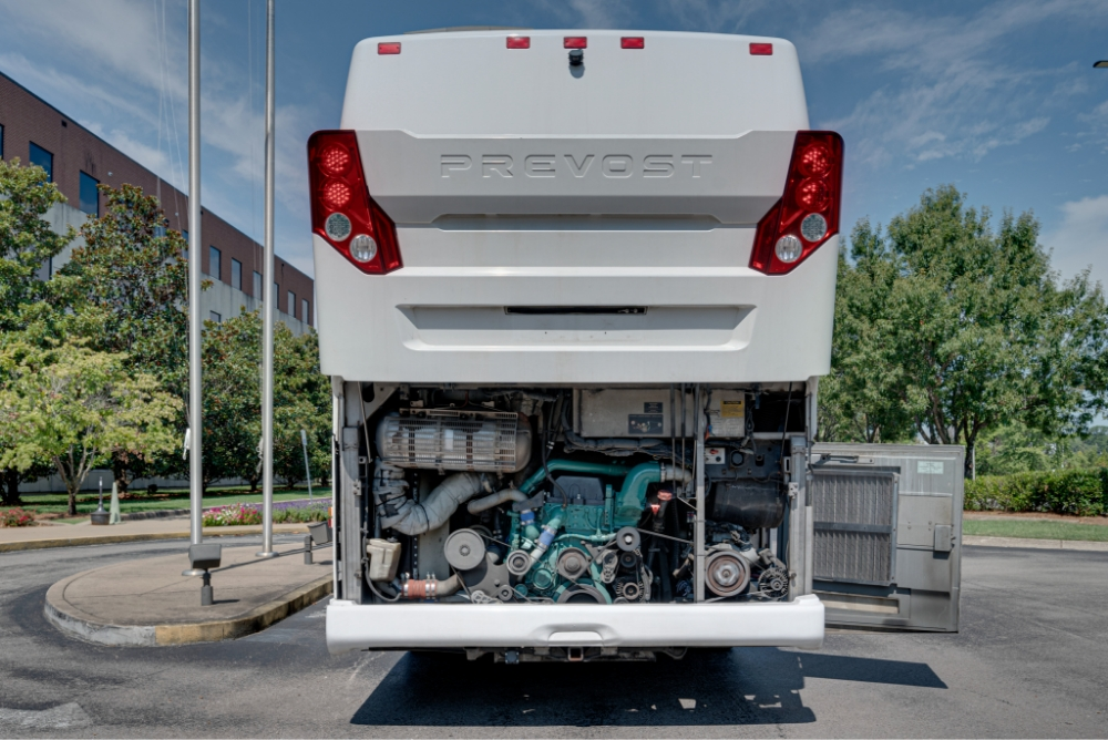 Rear view of a Prevost H345 bus conversion for sale with the engine compartment open, showcasing the well-maintained engine, perfect for long-distance travel as an entertainer bus.