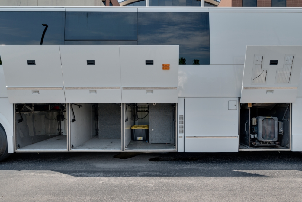 Open storage compartments on the side of a Prevost H345 bus, displaying the spacious and organized storage available for road trips and equipment.
