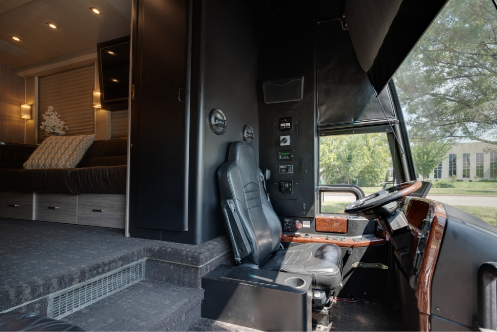 View of the driver’s seat and entrance to the luxurious interior of a Prevost H345 bus, emphasizing comfort and ease of access for long-distance trips.