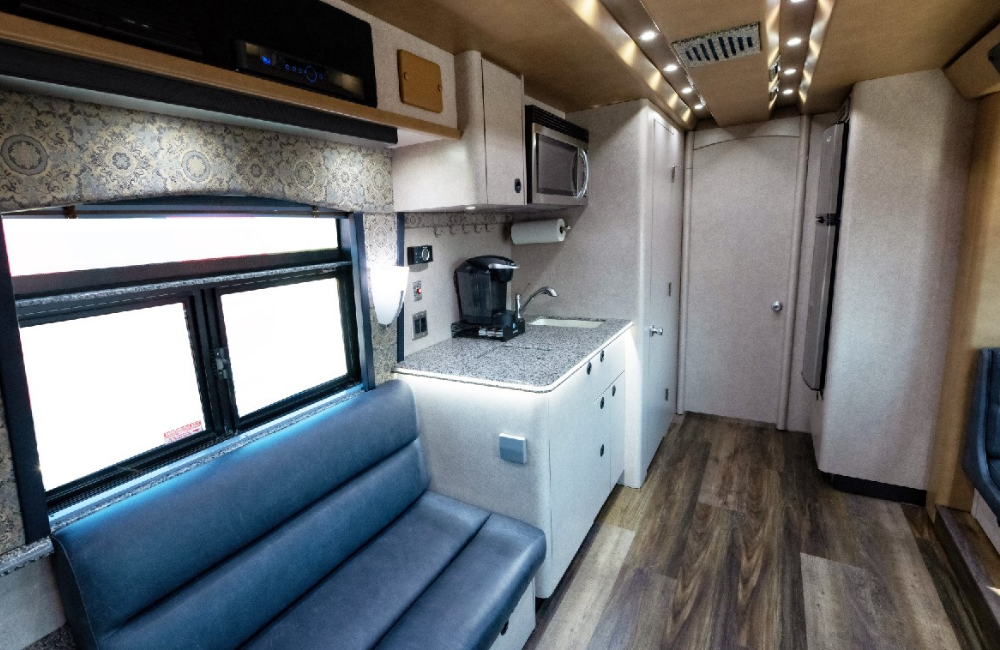 Lounge and dining area inside the 2007 Prevost XLII, complete with booth seating and entertainment features