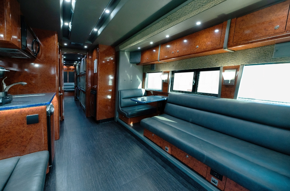 Rear lounge area of a 2006 Prevost XLII bus conversion for sale, highlighting a sleek design and ambient lighting for entertainment or relaxation.