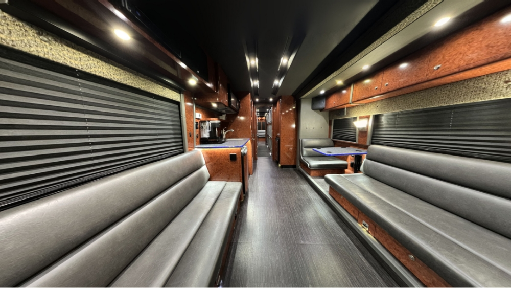 Spacious lounge area inside a 2006 Prevost XLII bus conversion for sale, featuring comfortable seating for travel and entertainment purposes.
