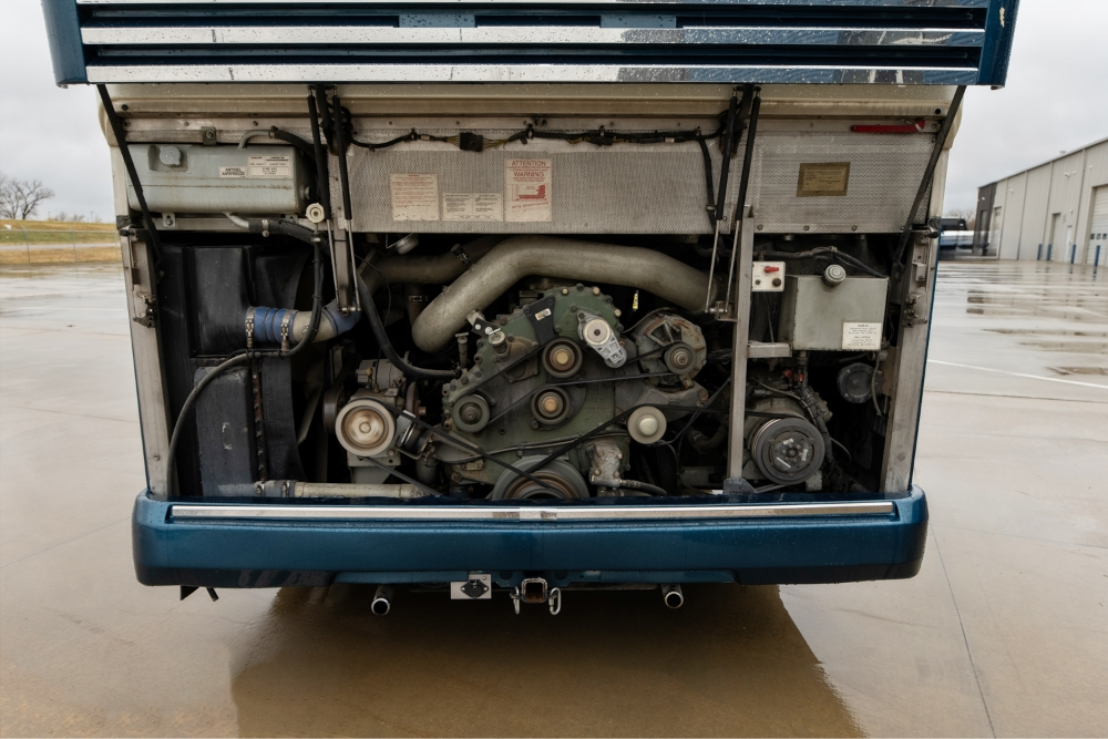 Close-up of the rear engine and mechanical system of a 2000 Prevost H345 motorhome, emphasizing its powerful and well-maintained setup for long trips.