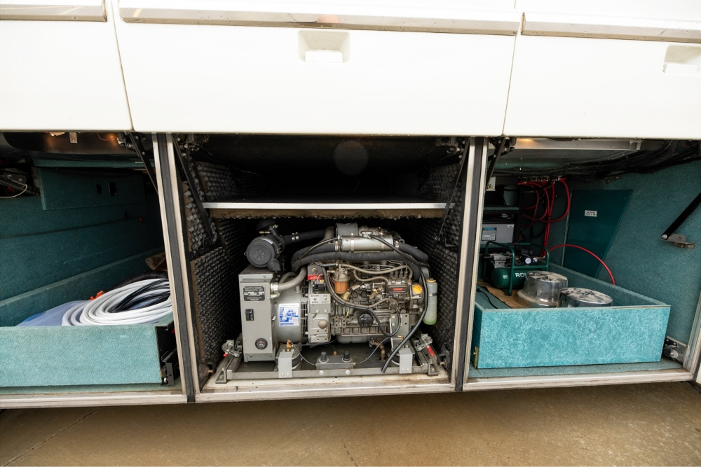 View of the open engine compartment of a 2000 Prevost H345 bus conversion, displaying well-maintained mechanical systems for reliable performance.