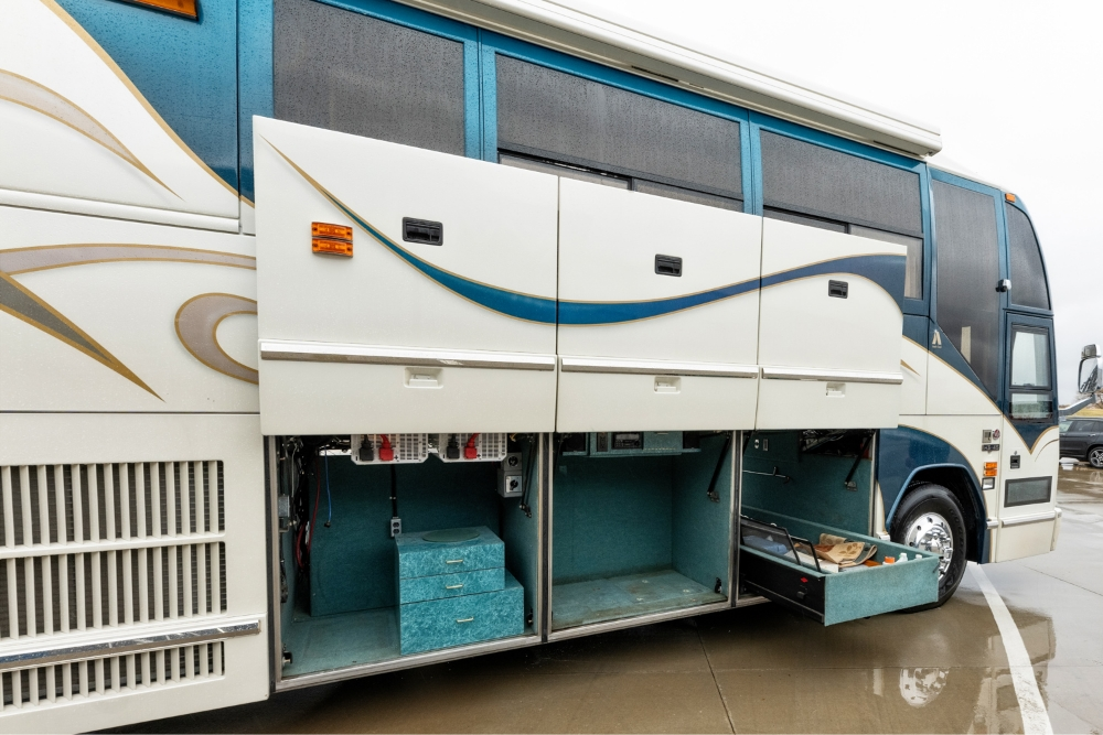 Side view of the 2000 Prevost H345 with open storage compartments, providing ample space for equipment and utilities in this motorhome conversion.