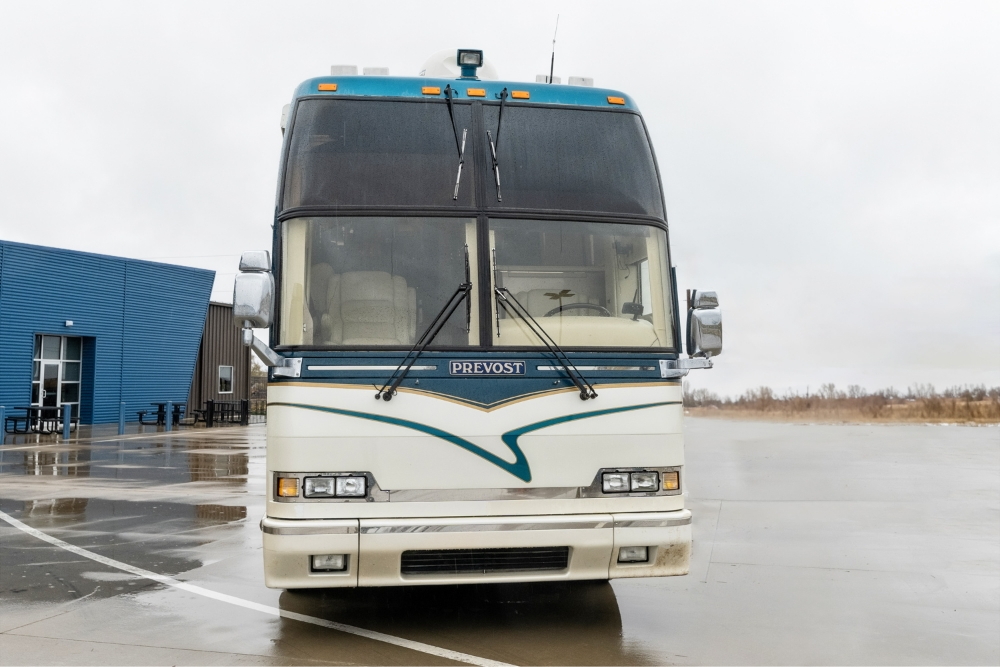 Front view of a 2000 Prevost H345 motorhome for sale, featuring a modern exterior and large windshield for optimal driving visibility.
