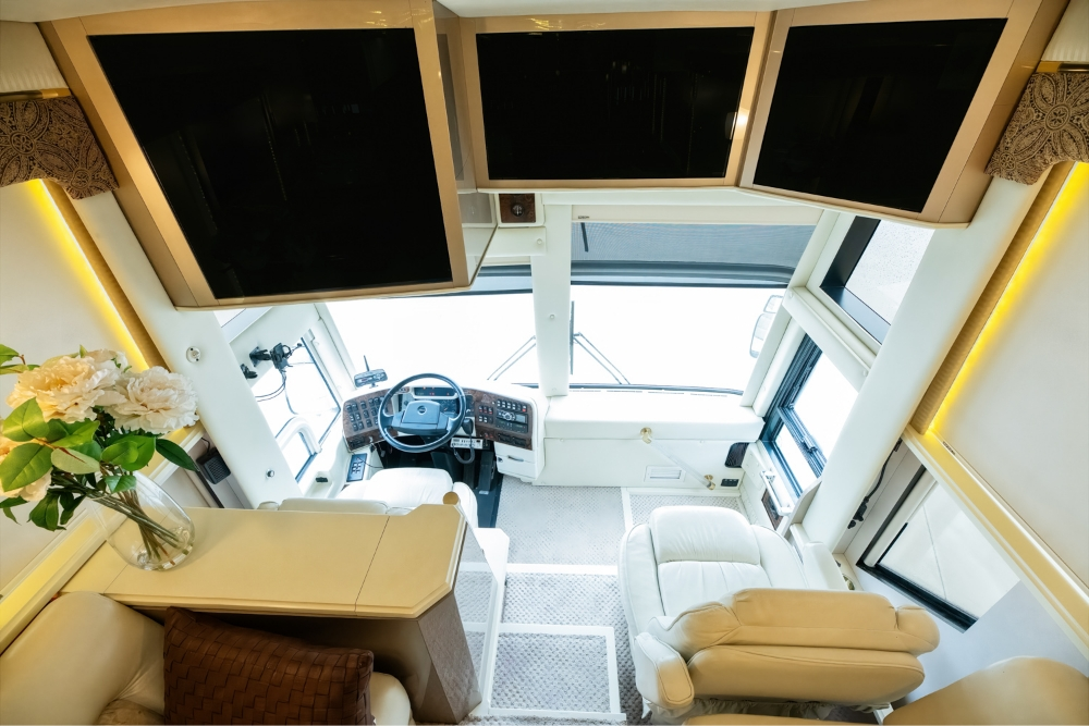 Front view of the driver's area in a 2000 Prevost H345 motorhome, with modern controls and comfortable front seating for long road trips.