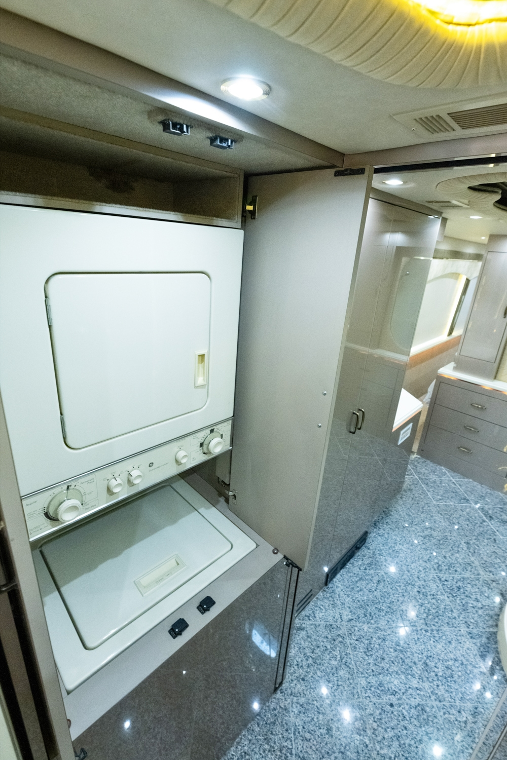 Laundry area inside a 2000 Prevost H345 motorhome for sale, featuring a washer and dryer for added convenience on long trips.