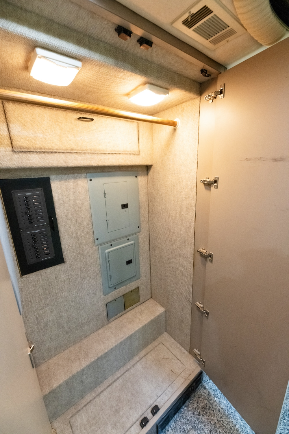 Storage closet with electrical panel inside a 2000 Prevost H345 bus conversion, providing easy access to utilities and extra storage space.