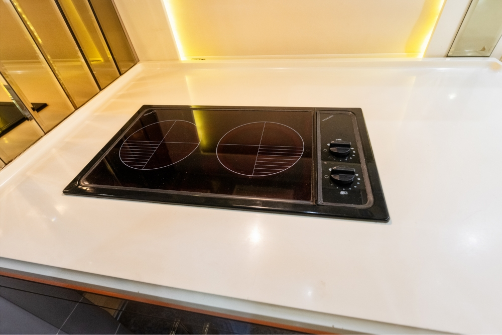 Modern kitchen countertop with a built-in stove inside a 2000 Prevost H345 motorhome, offering high-end amenities for a fully equipped mobile kitchen.