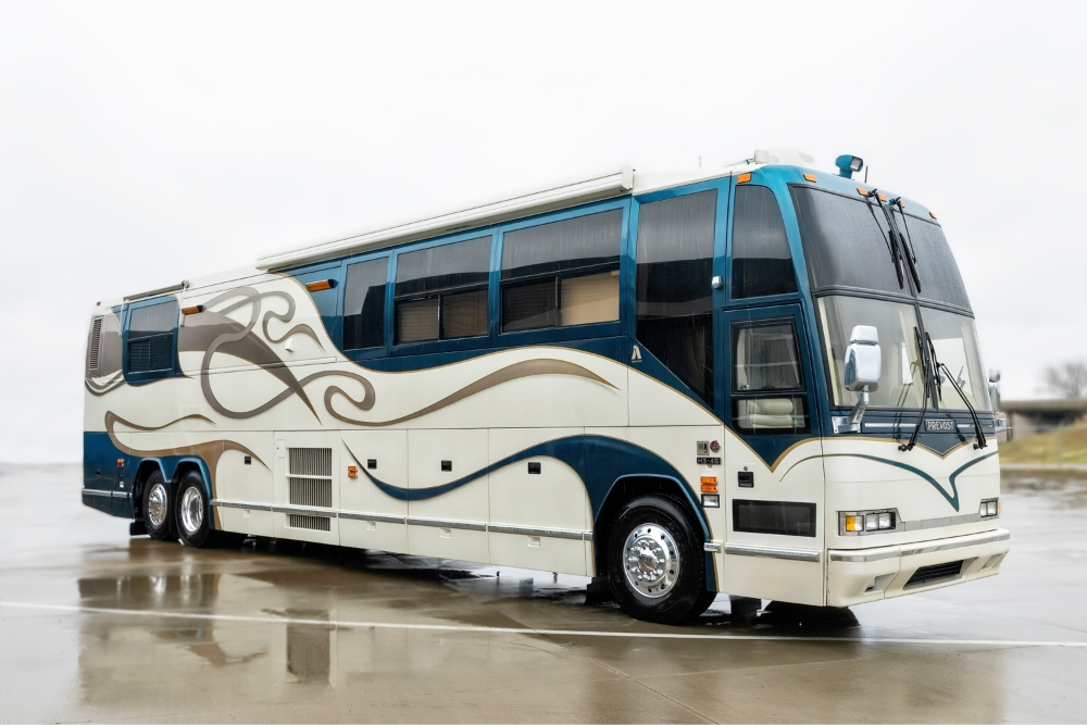 Side view of a 2000 Prevost H345 bus conversion for sale, showcasing the sleek design and large windows, ideal as a luxury motorhome.