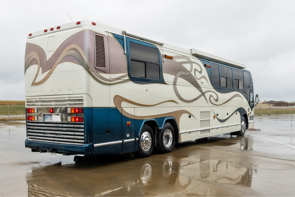 Rear angled view of a 2000 Prevost H345 motorhome for sale, highlighting its streamlined design and well-maintained exterior for long-distance travel.
