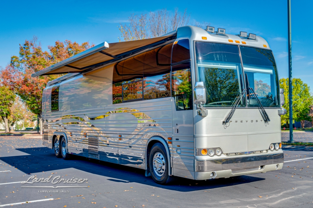 Prevost entertainer bus with extended awning, ideal for touring and outdoor events.