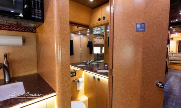 Motorhome half bath with Corian countertop vanity and ample storage space