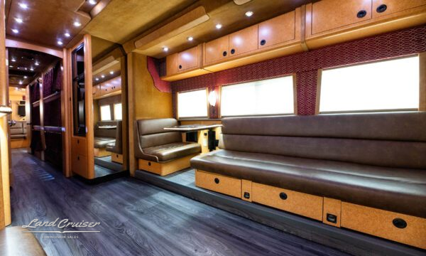 Leather sofa in motorhome front lounge area with window shades and ambient lighting