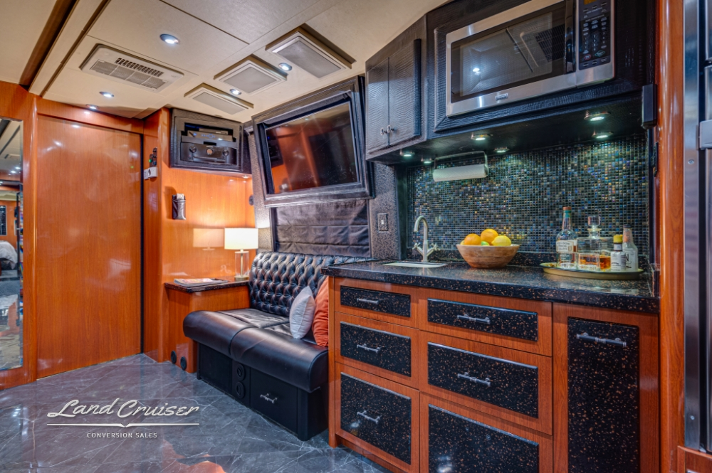 Compact galley kitchen with stainless steel appliances in 2006 Prevost.