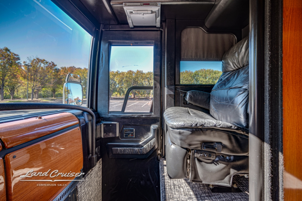 Driver cockpit view in Prevost XLII tour bus, with panoramic windows.