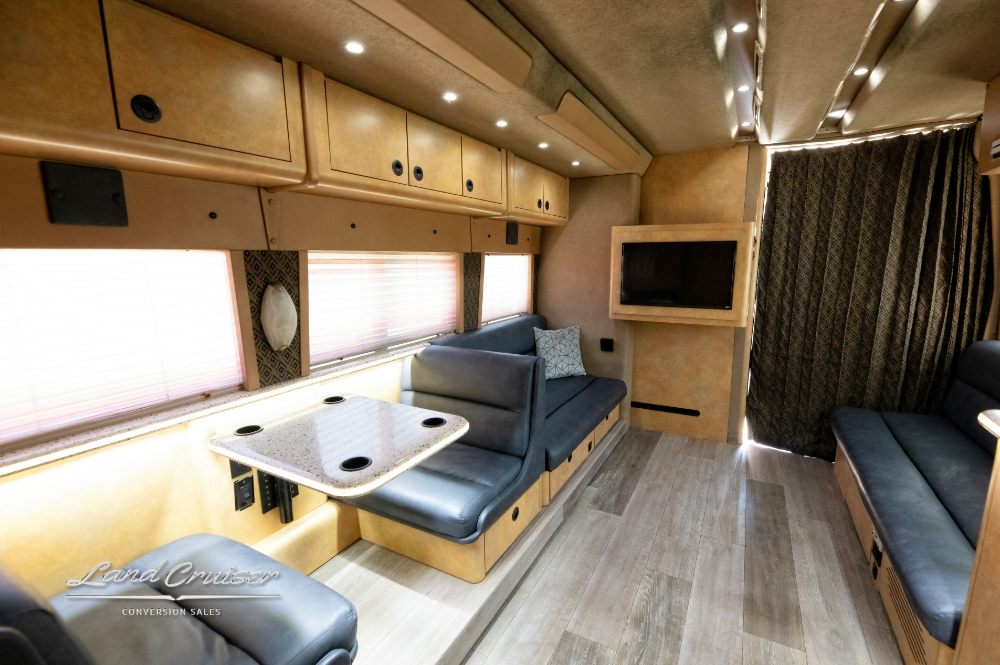 Kitchen view inside a prevost bus that shows the microwave & sink along with beautiful backsplash
