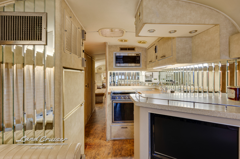 View of a bus conversion kitchen with a kitchen-aid hot water dispenser