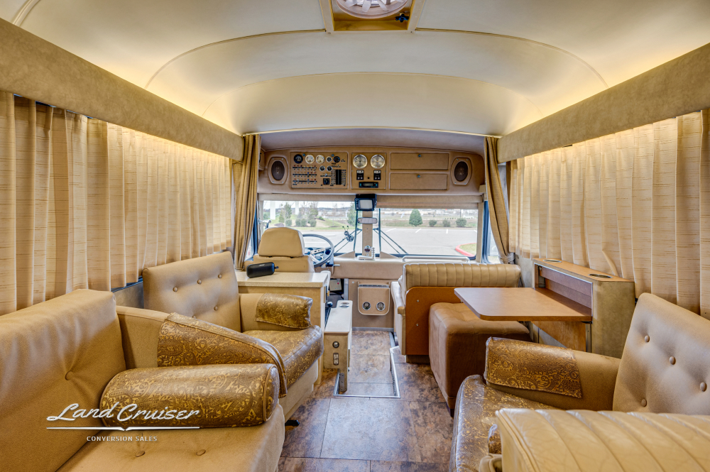 A view of the couch and dining area inside a coach that was converted by Custom Coach Corporation