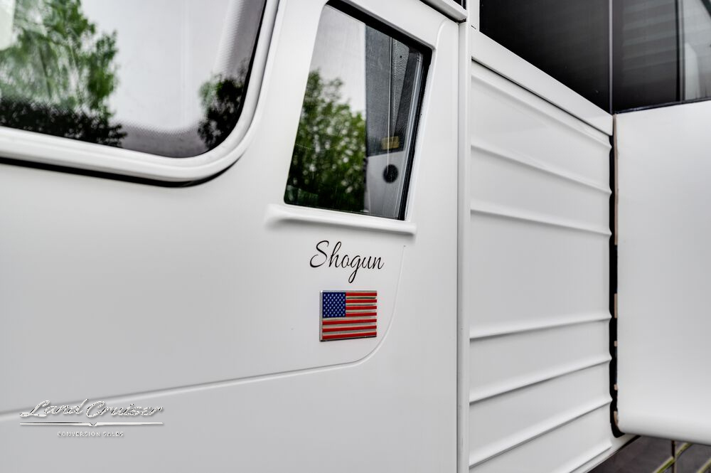 Close-up of Shogun branding and American flag decal on the side of the 2004 Prevost XLII coach