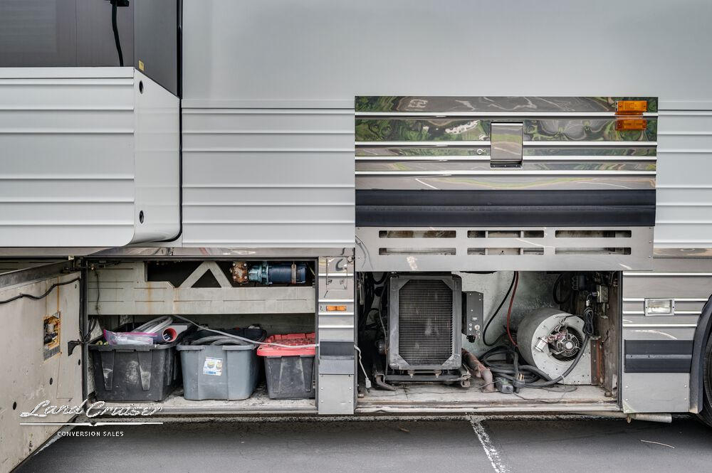 Side storage bays of Shogun coach showing electrical system, batteries, and maintenance access