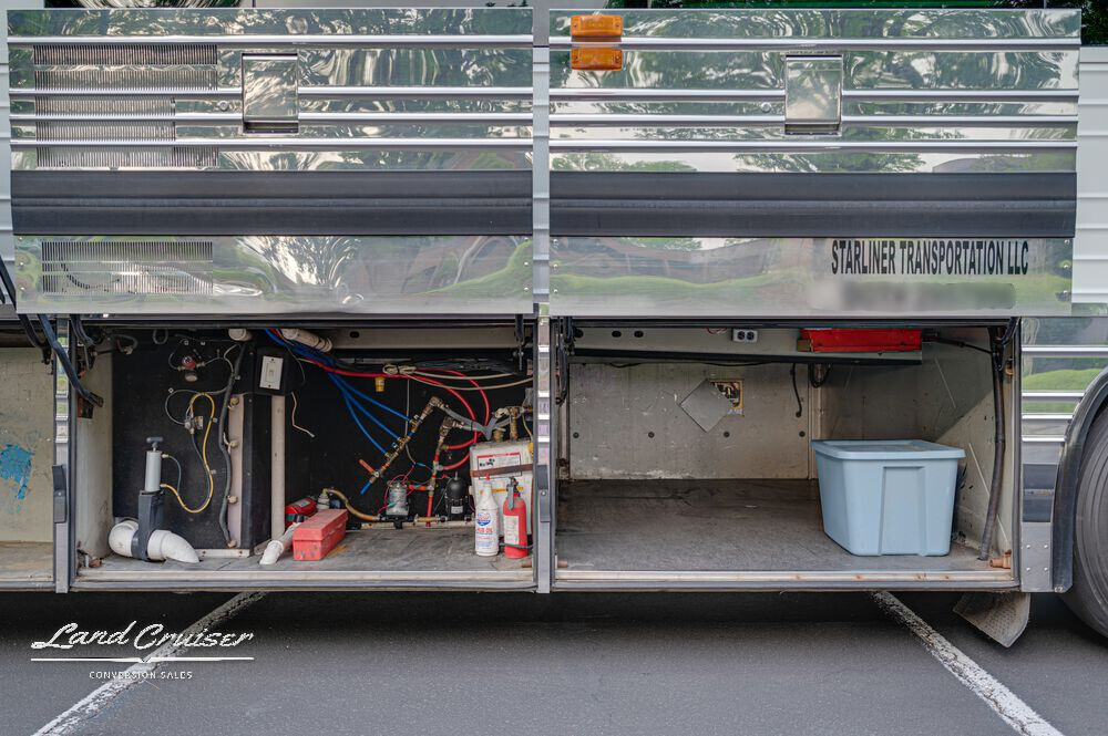 Driver-side view of Prevost entertainer coach with utility bays and open storage compartments
