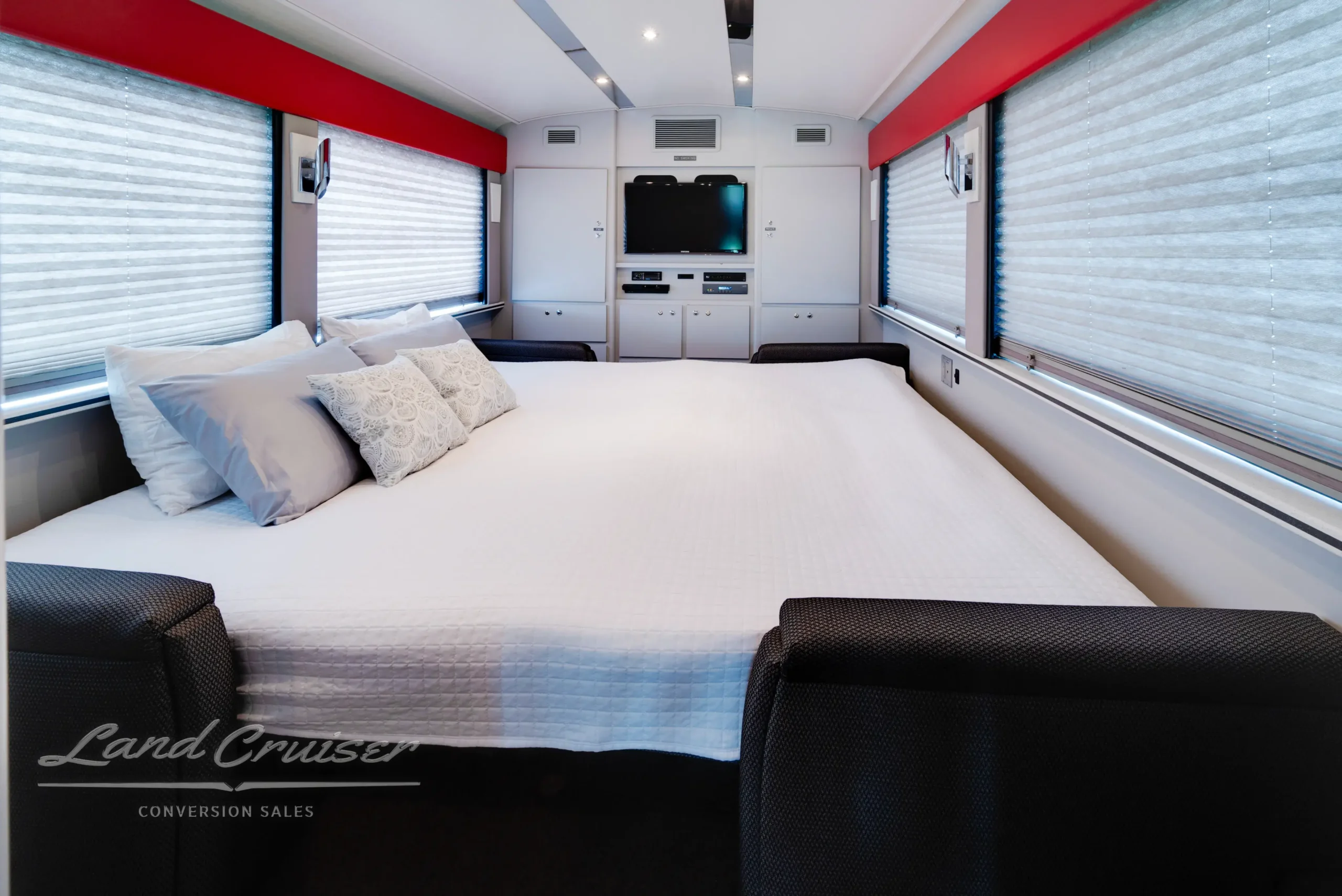 Executive MCI coach bedroom with entertainment center, ambient ceiling lighting, and full-size bed