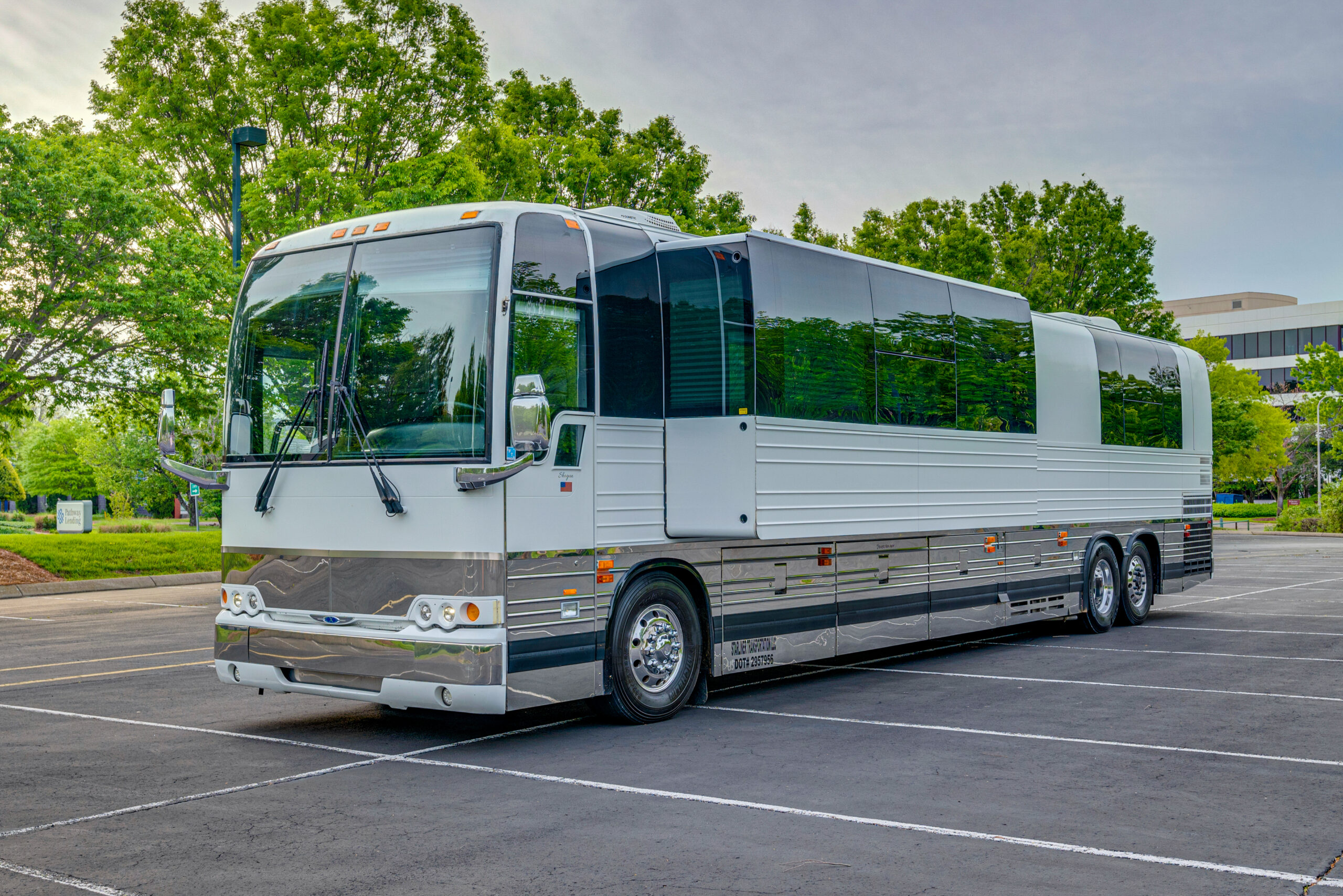 Exterior of a white 2004 Prevost XLII for sale with a single slide out being featured in the image.