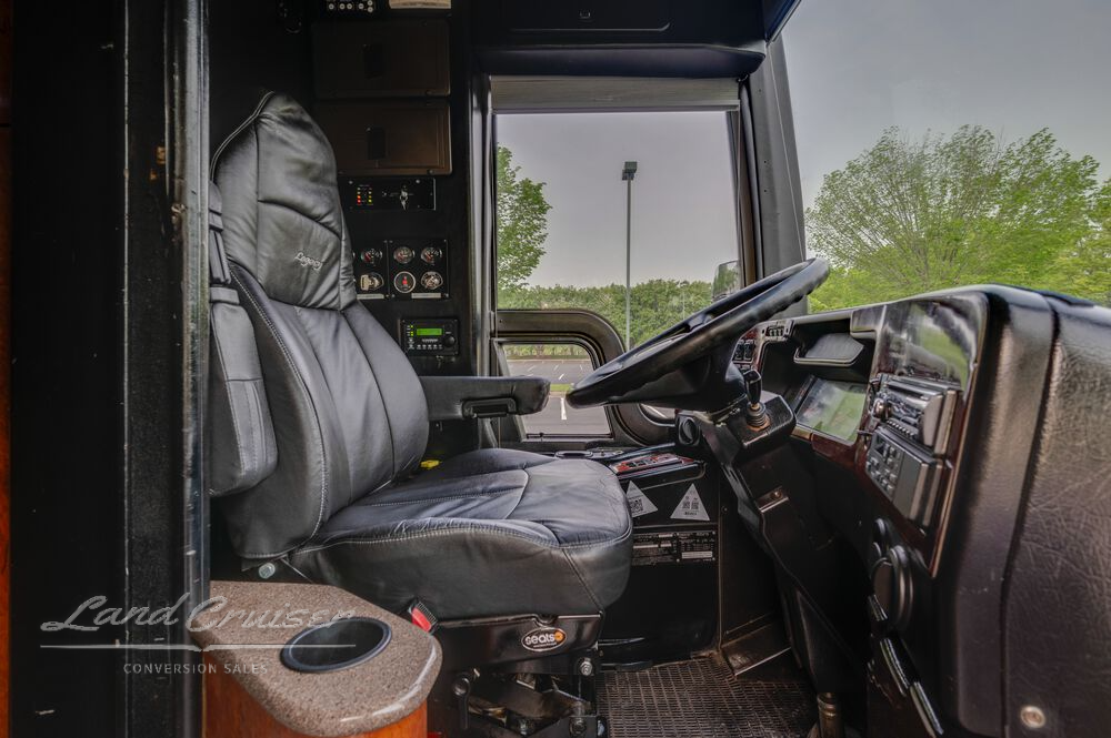 Cockpit of Prevost entertainer coach with gray leather driver seat and full instrument cluster