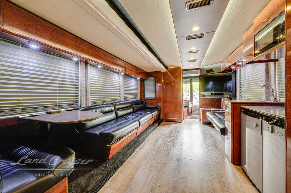 Kitchen galley and booth dinette in Prevost entertainer coach with Corian surfaces and Whirlpool appliances