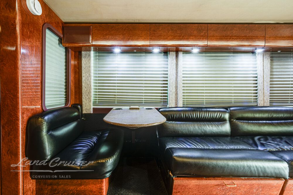 Kitchen galley and booth dinette in Prevost entertainer coach with Corian surfaces and Whirlpool appliances