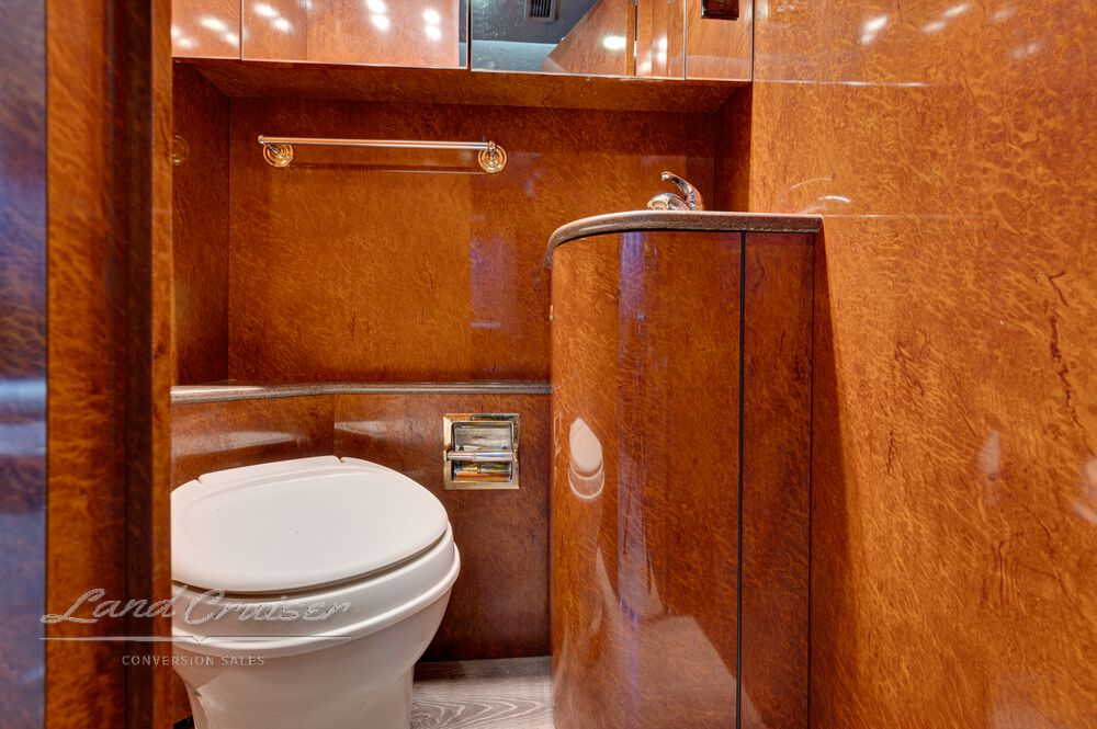 Bathroom in Shogun Prevost entertainer coach with modern vanity, round toilet, and storage cabinet