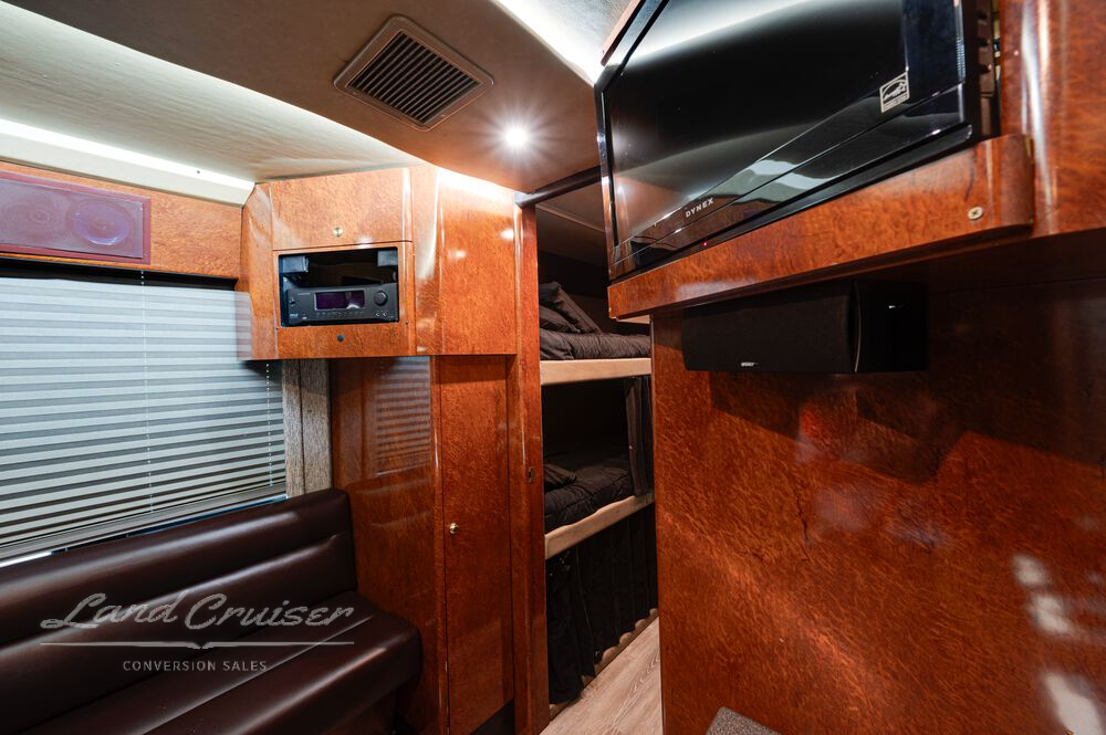 Entertainment console in Shogun rear lounge with mounted flat screen TV, storage cabinets, and mirror paneling