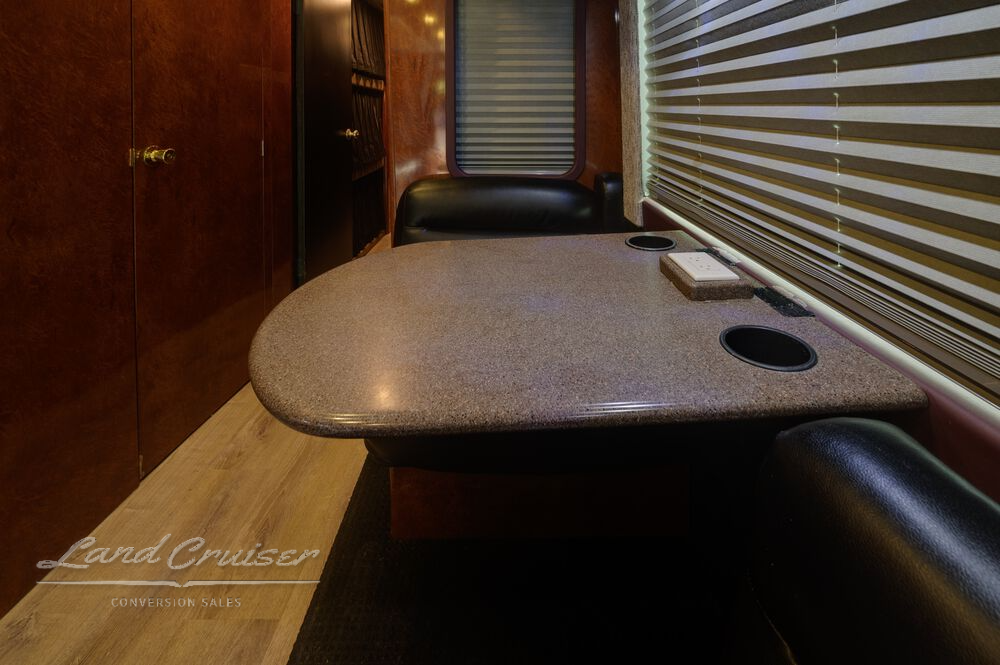 Booth-style dinette in Shogun entertainer coach with Corian tabletop and wood-paneled window blinds