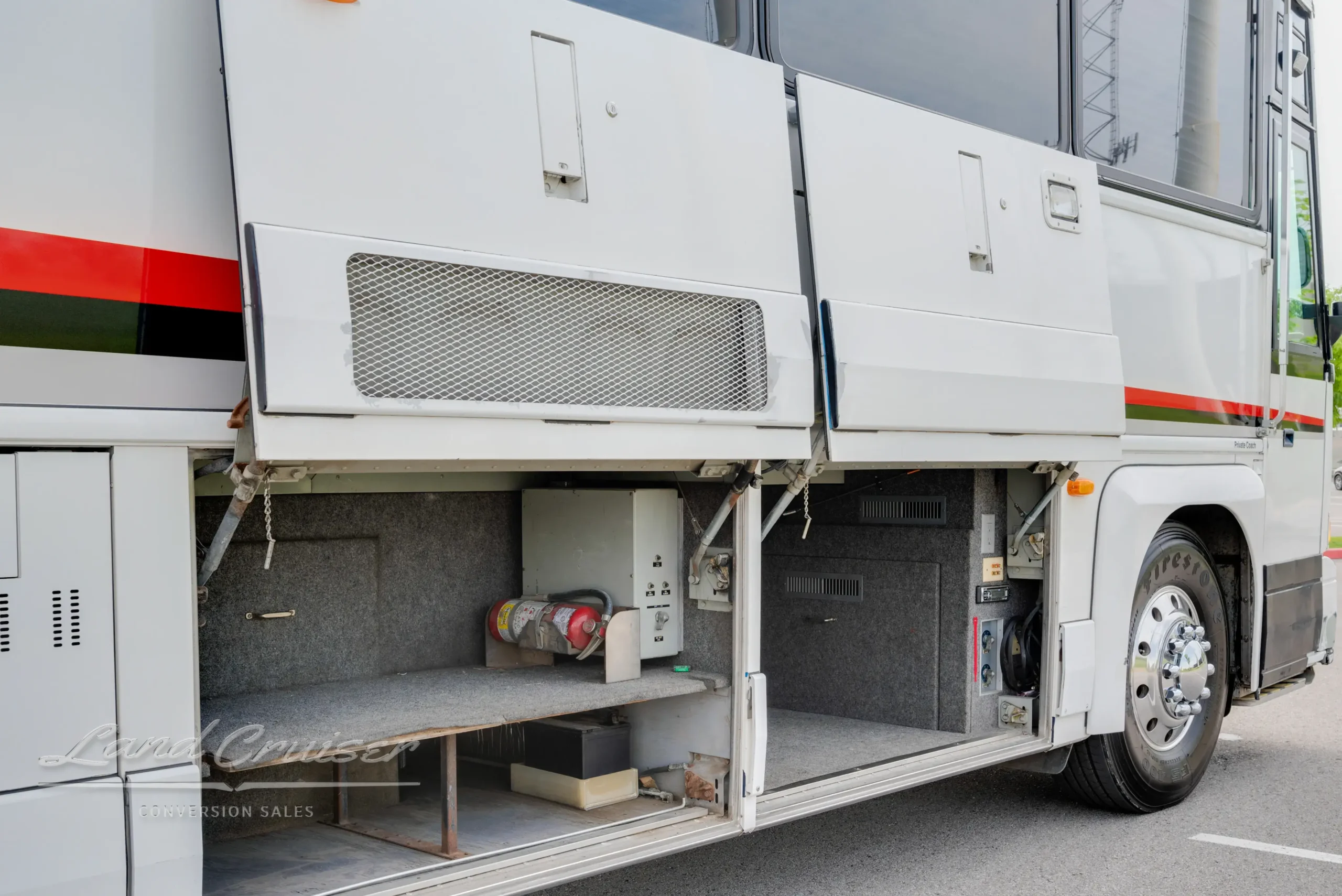 Open luggage and utility compartments on MCI bus conversion with storage shelves and electrical access