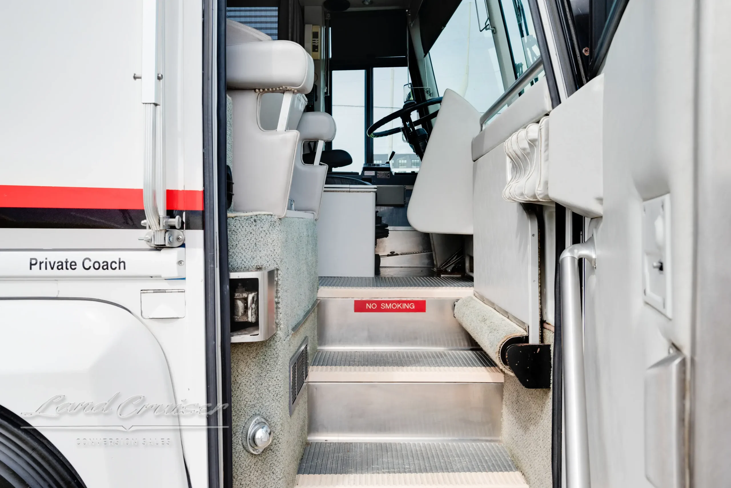 Entry stairs and cockpit access of MCI Executive Coach featuring Atlas II air ride seat and control panel