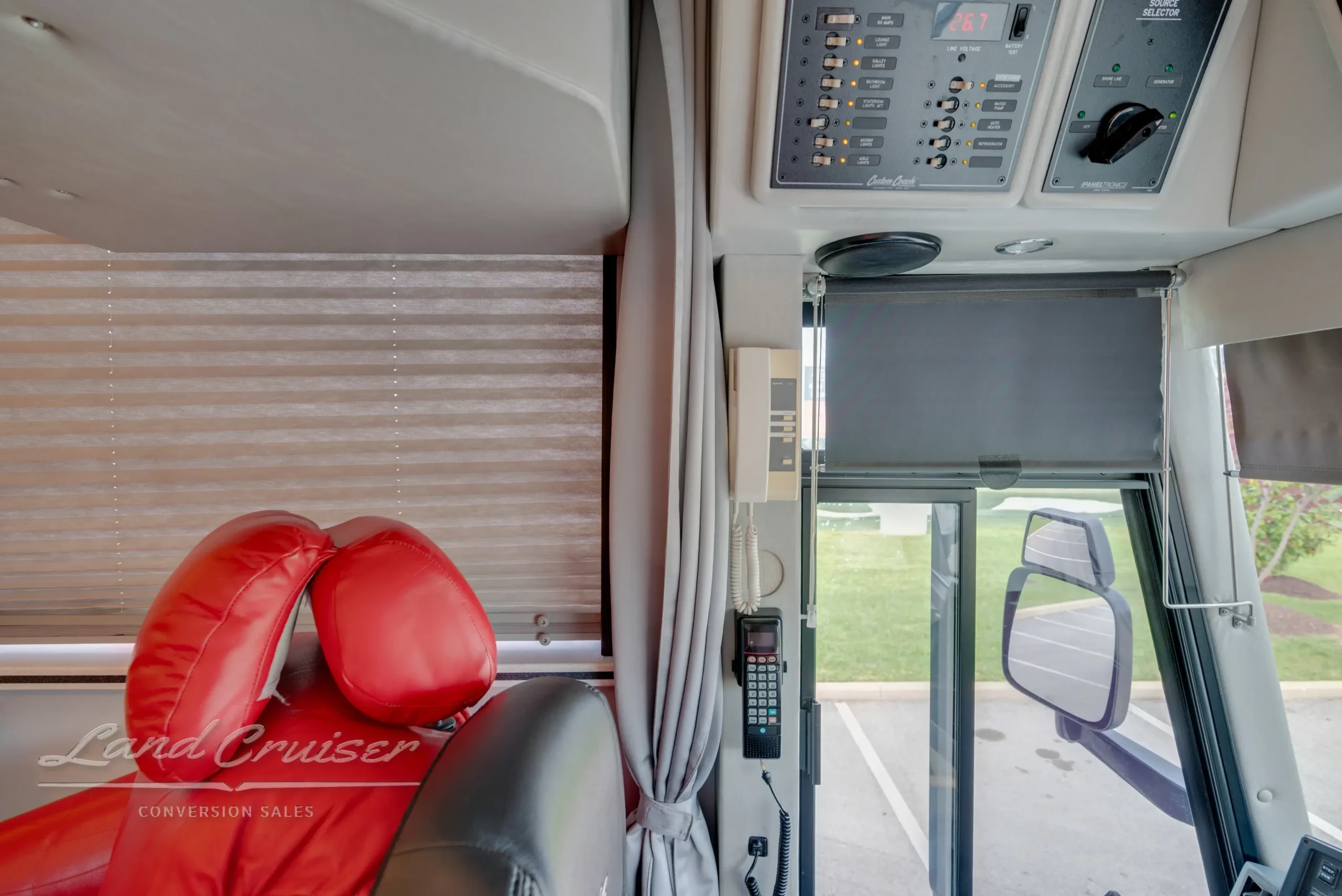 MCI 102-DL3 entry doorway showing intercom, red captain seat, and overhead electrical controls