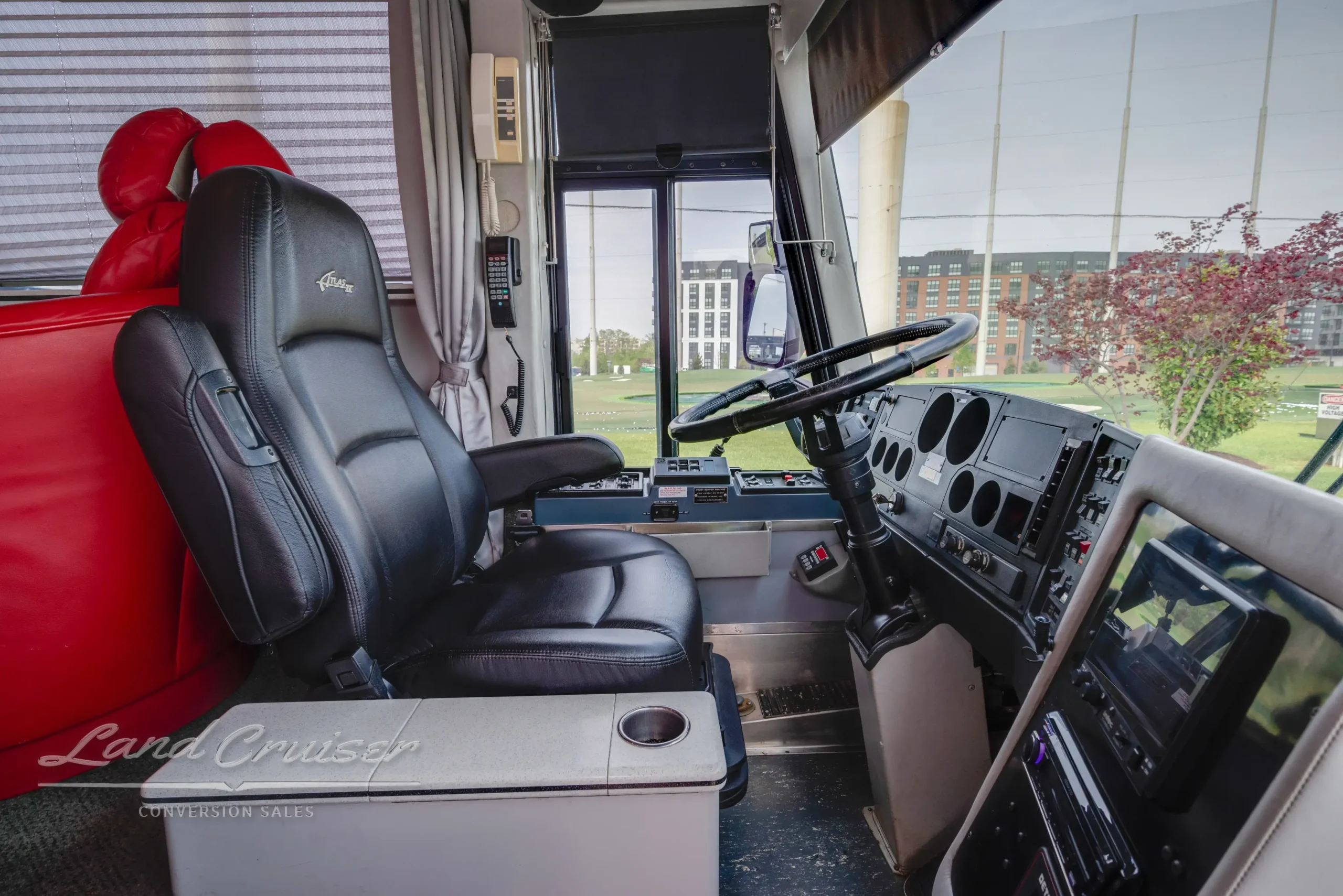 Side view of MCI bus driver station featuring touchscreen controls and ergonomic captain chair