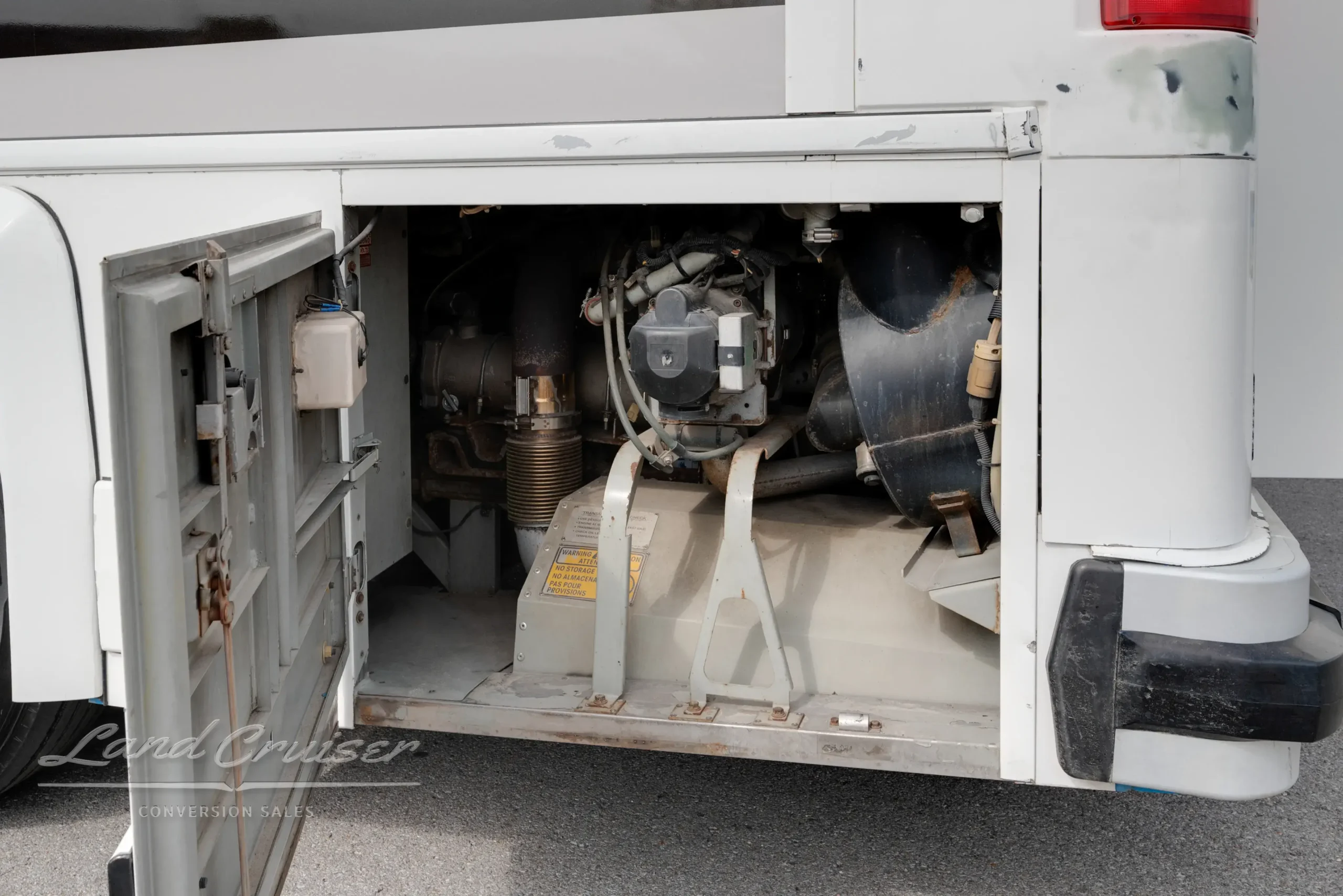 Service bay on MCI bus revealing air compressor and mechanical system components