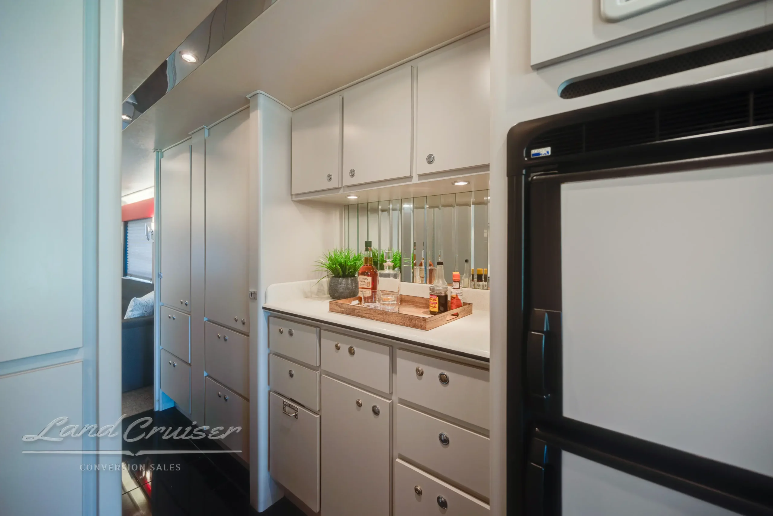MCI Executive Coach galley featuring mirrored backsplash, Corian countertops, and display tray with fruit and greenery
