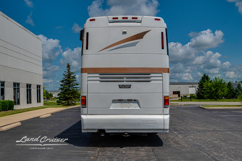 Full rear view of MCI motorhome parked in open lot