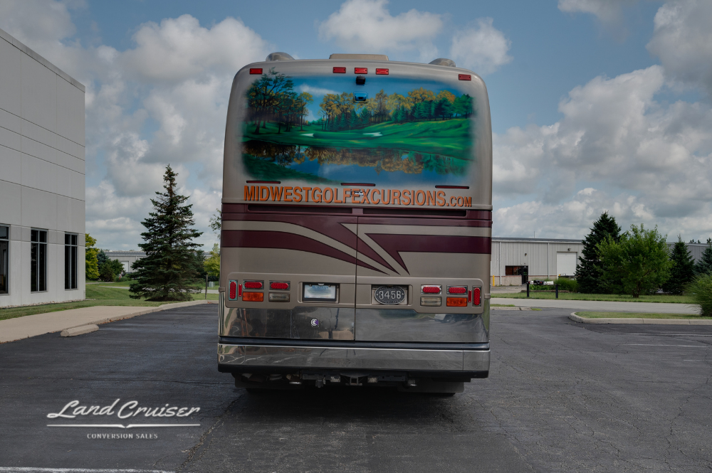 Direct rear view of 2002 Prevost XLII showing taillights, backup camera, and signature airbrushed mural