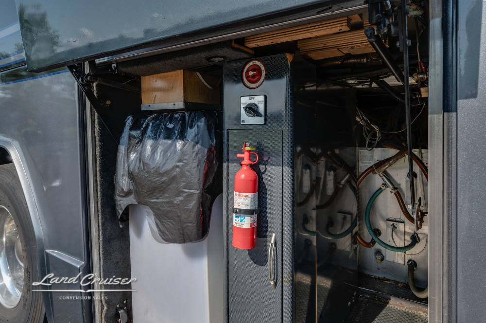 Storage cabinet area featuring mounted fire extinguisher, waste bin, and control switches.