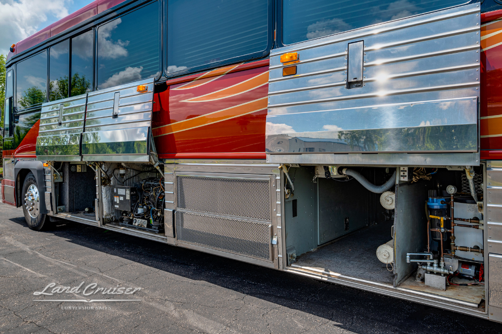 Close-up of plumbing bay and lower compartments on passenger side of Custom Coach 4510