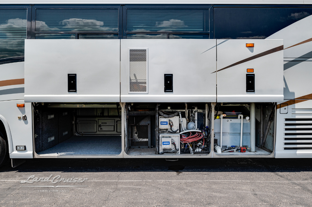 Open storage bays showing generator and electrical components on MCI motorhome