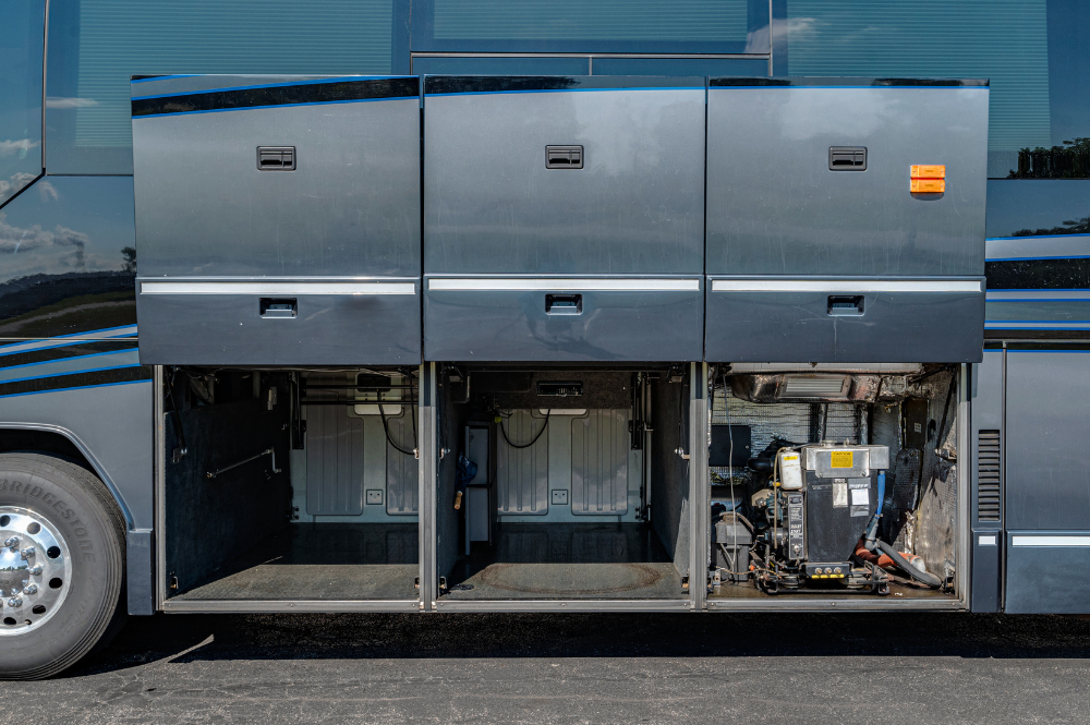 Three fully opened access doors displaying utilities and power components along the side of the coach.