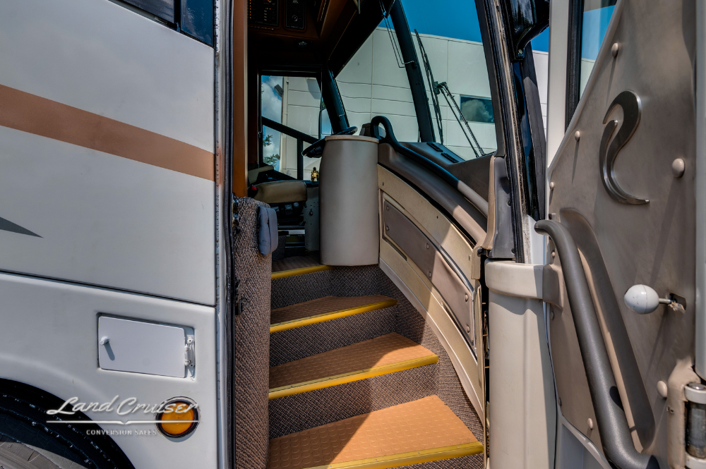 Entry steps leading into MCI motorhome with tan carpeting